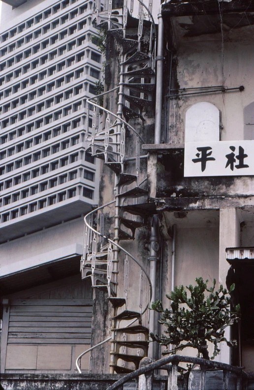 the side of a building with stairs and sign above