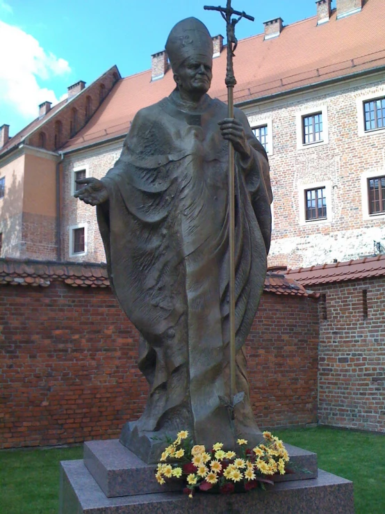 a stone statue sits outside near the brick building