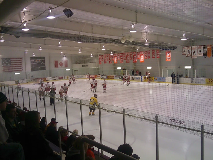 hockey players playing inside an indoor facility for people watching