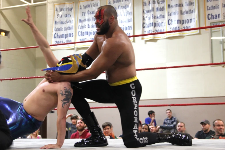 a wrestler kneels as another wrestler kneels in front of him