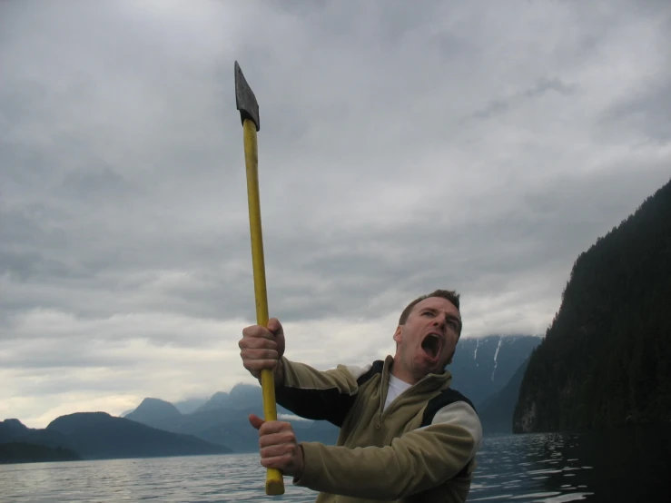 a man on a boat with a large pole in his hands