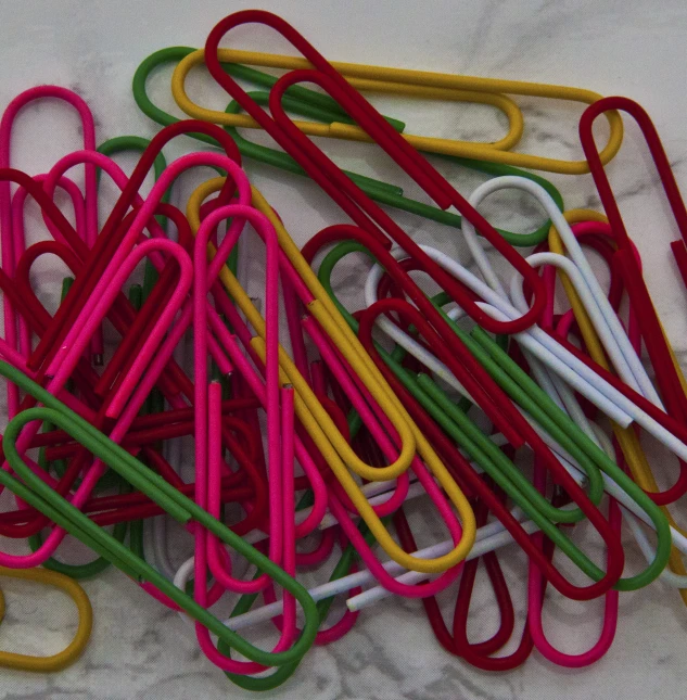 many different colored paper clips arranged in a pile