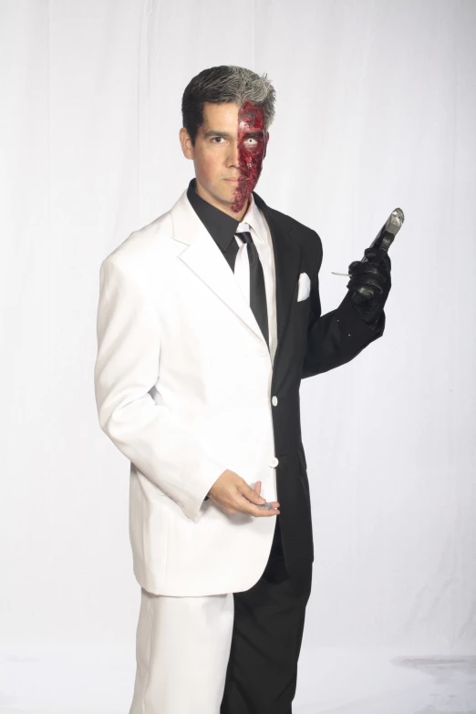 a man wearing a white suit is holding a gun