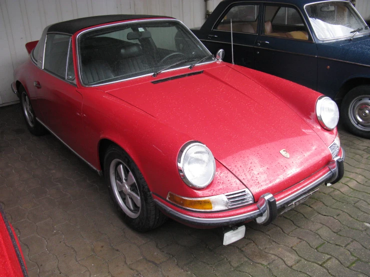 a red and black porsche parked next to each other