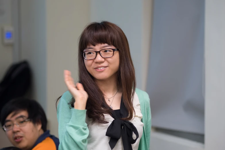 a young woman gives the middle finger sign with another guy behind her