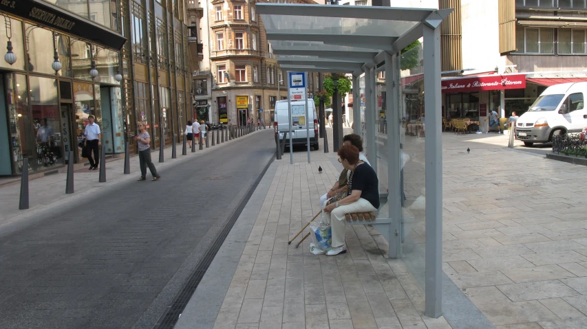 a woman sitting on a bench outside of an outlet