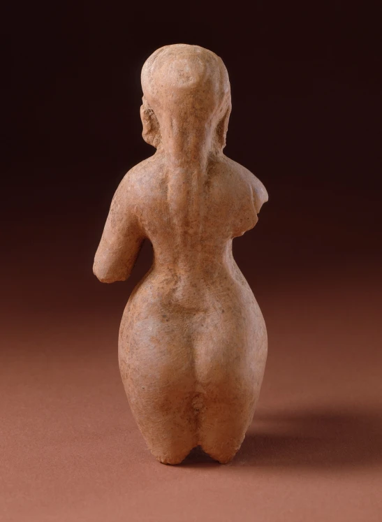 a close up of an clay figure on a brown background