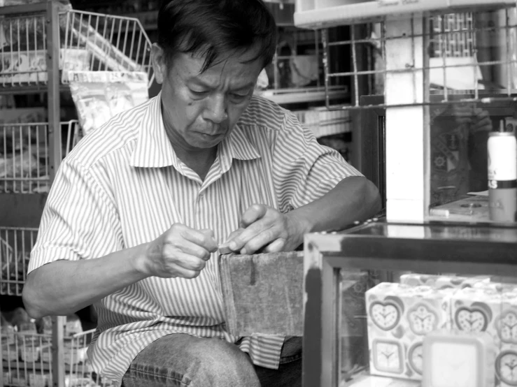 a man in striped shirt working on a piece of wood