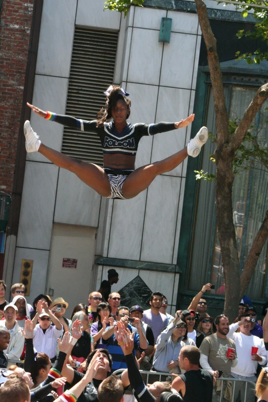 a  in an aerial circus dress juggles into the crowd