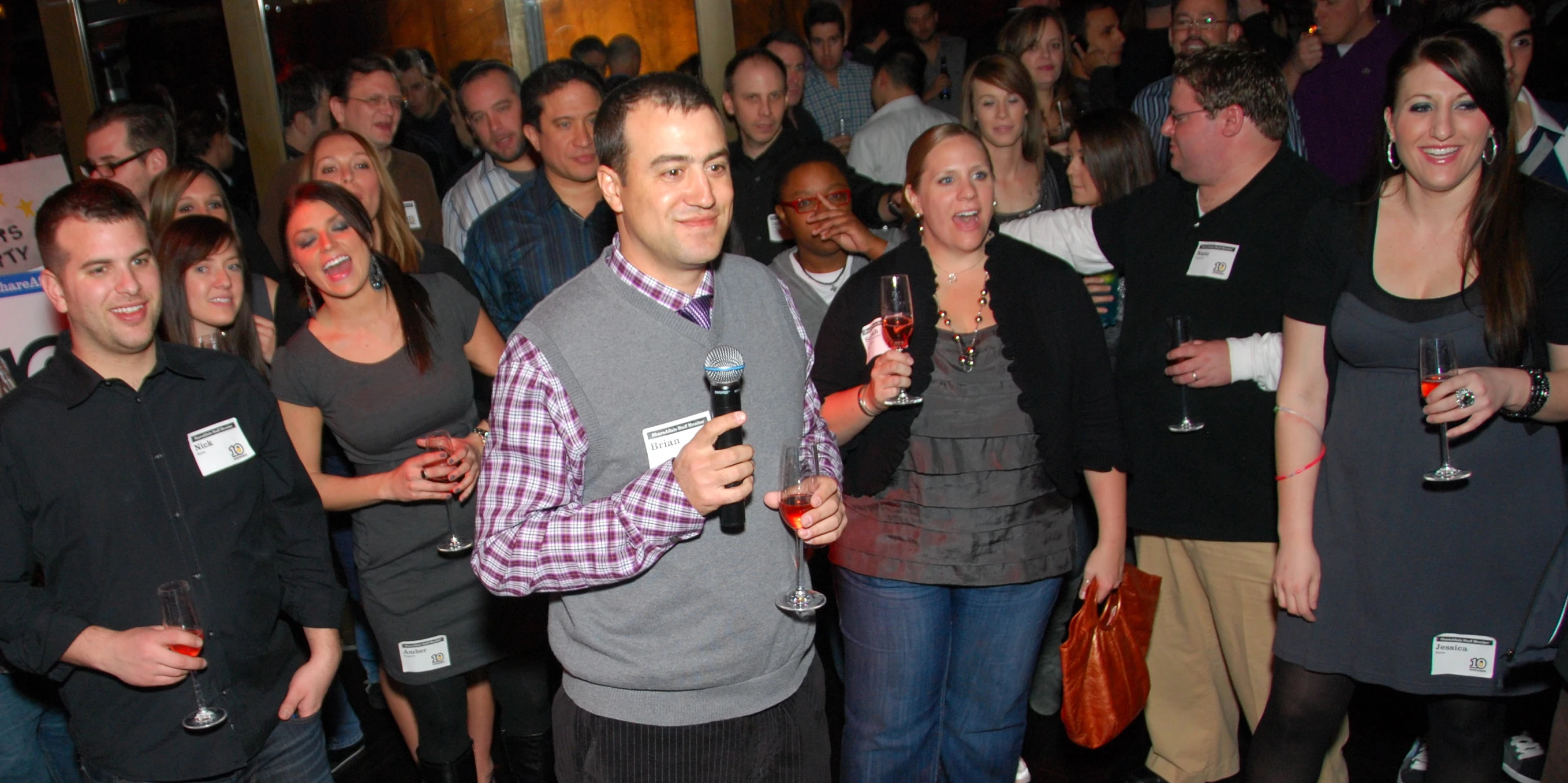 many people are talking and having drinks in front of a camera