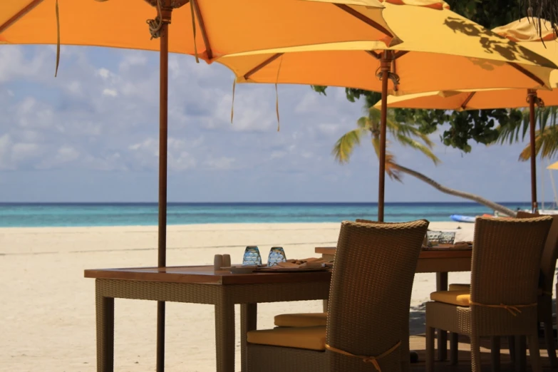 a dining area with a table and chairs underneath an umbrella