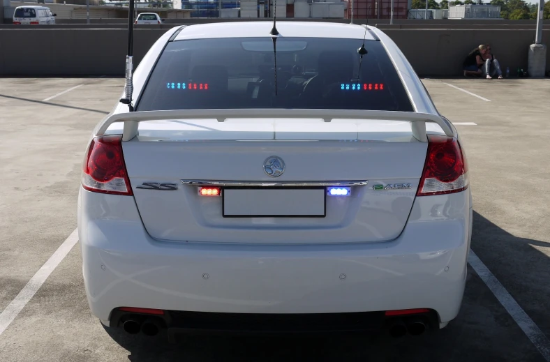 a white car parked in a parking lot with its lights on