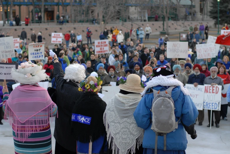 some people standing outside in front of a crowd holding signs