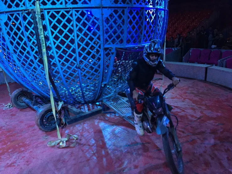 a man on a bike parked in a blue sculpture