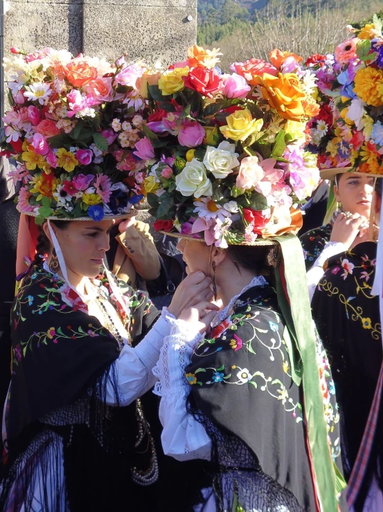 women wearing headdresses and floral crowns in traditional garb