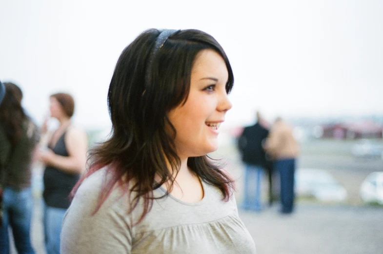 a woman smiling with many people in the background