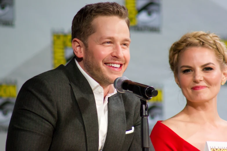 a man and woman smiling while standing next to each other