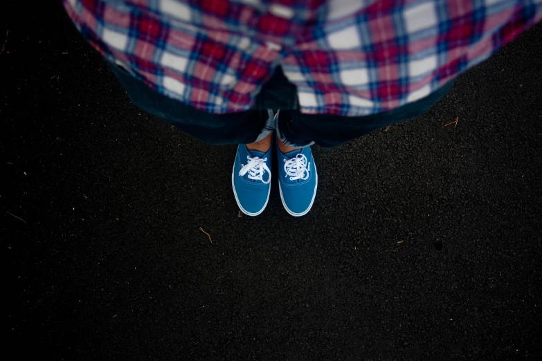 person wearing checkered pants and blue shoes