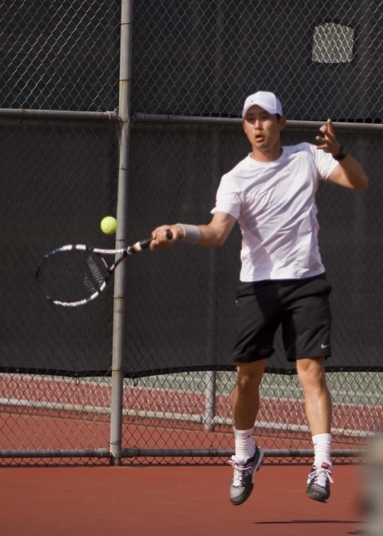 a male tennis player returning a hit to his opponent