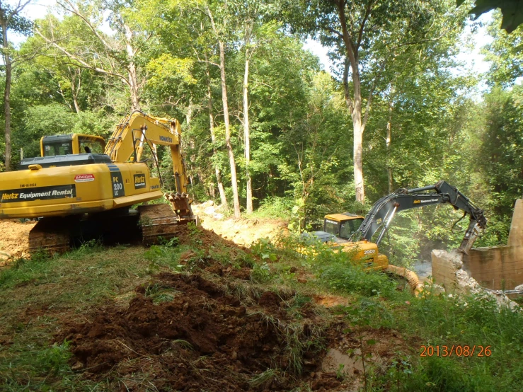 an excavating vehicle and bulldozer at work in the woods