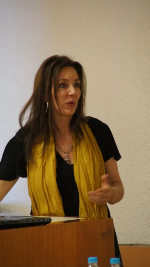 a woman speaking in front of a podium