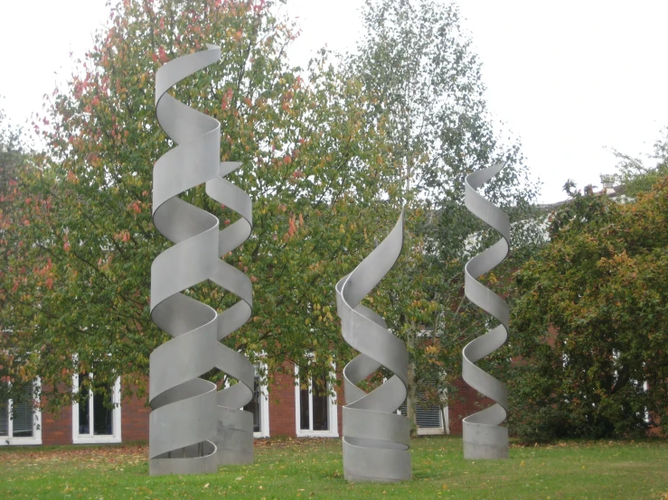 three large metal sculpture sitting in the middle of a park