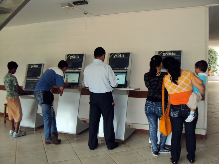 three men and one woman with bags at atms