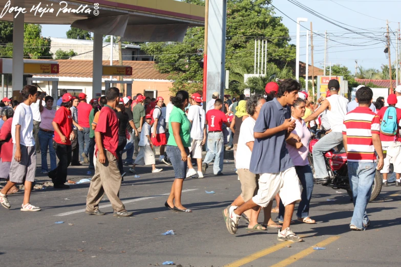 several young people walking across a street with buildings in the background