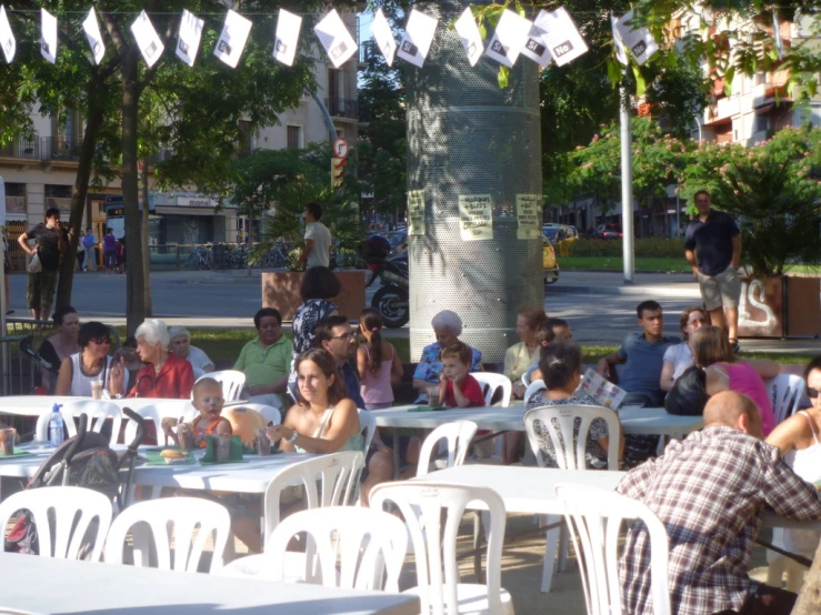 some people sitting at tables and one is standing