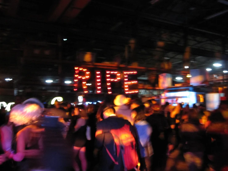 a crowded indoor area with people standing and sitting