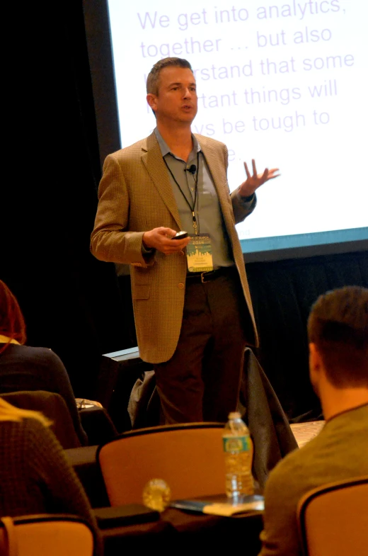 a man standing in front of a projector screen giving a presentation