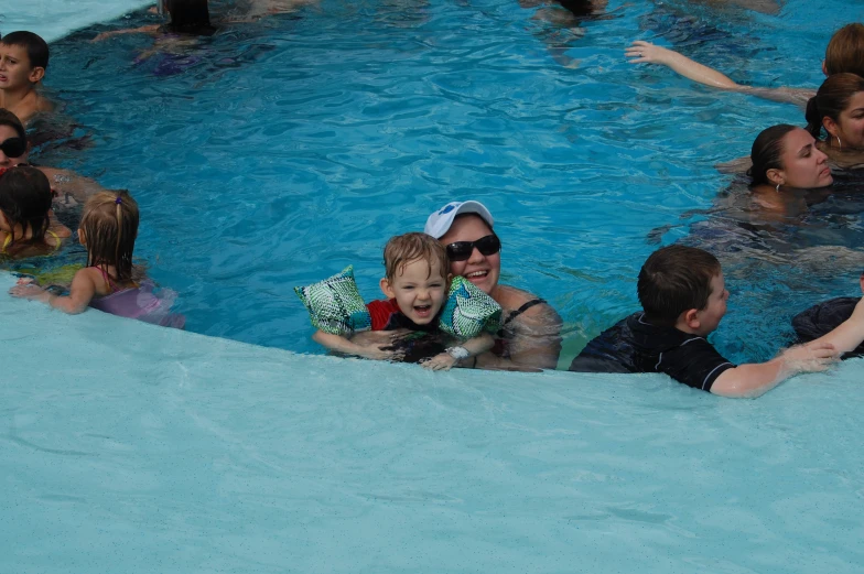 a woman in a swimming pool with some children