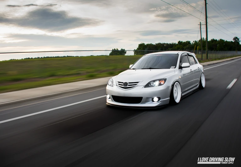 a silver car is moving down the road