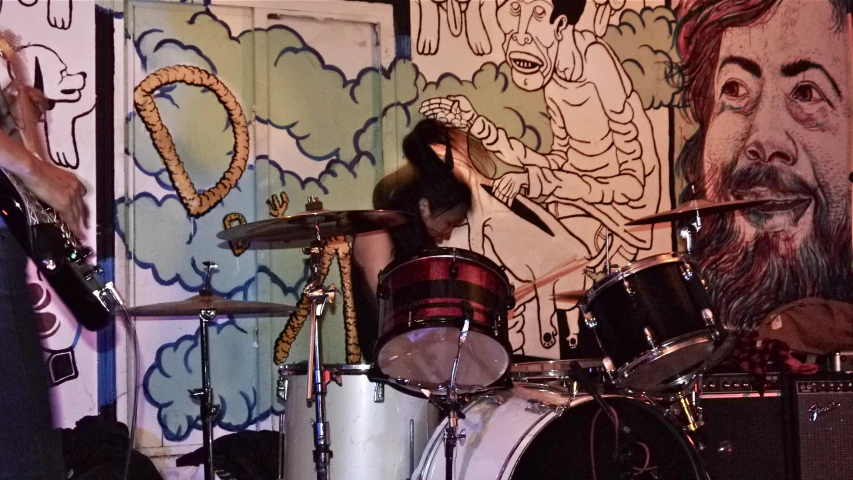 two young women playing drums in front of wallpaper