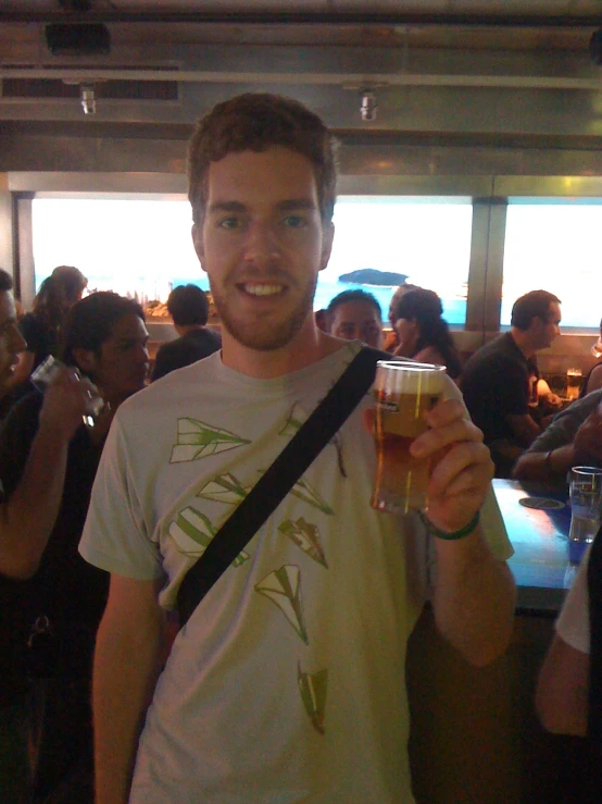 a man holding up a glass in a crowded room