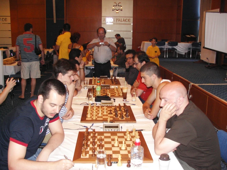 several people at a long table playing chess