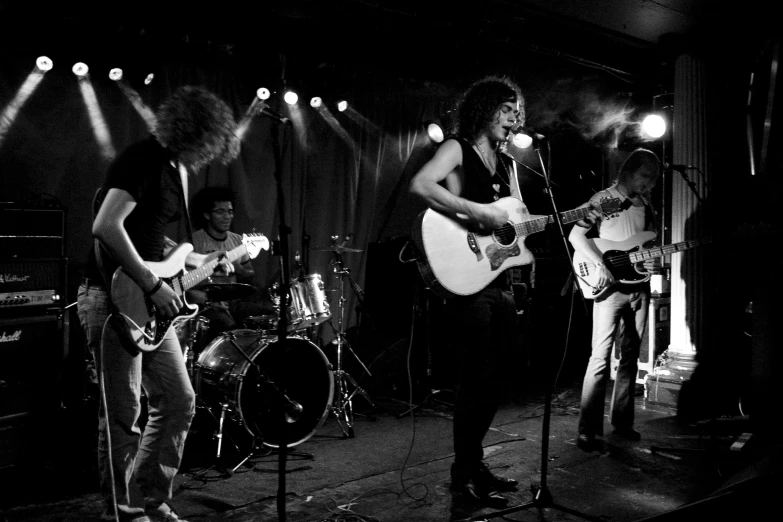 the band is performing with their guitars in front of spotlights