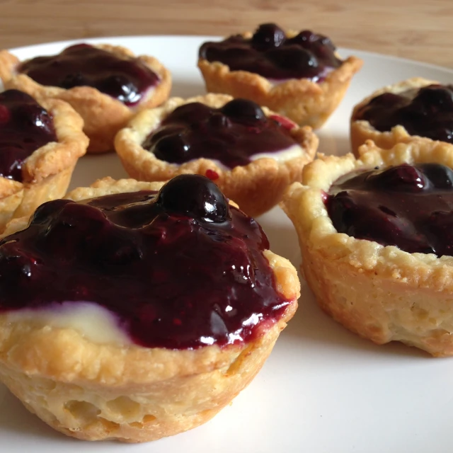 there is an image of some mini pies with berry toppings