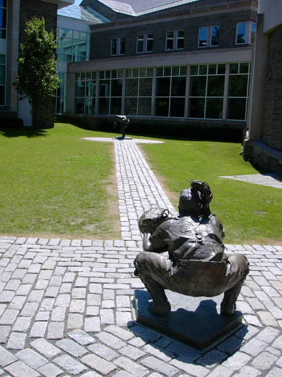 an old statue of a man sitting outside the university building