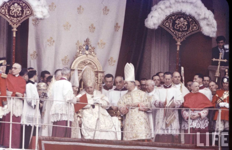 several people in front of a priest who has just received his degree