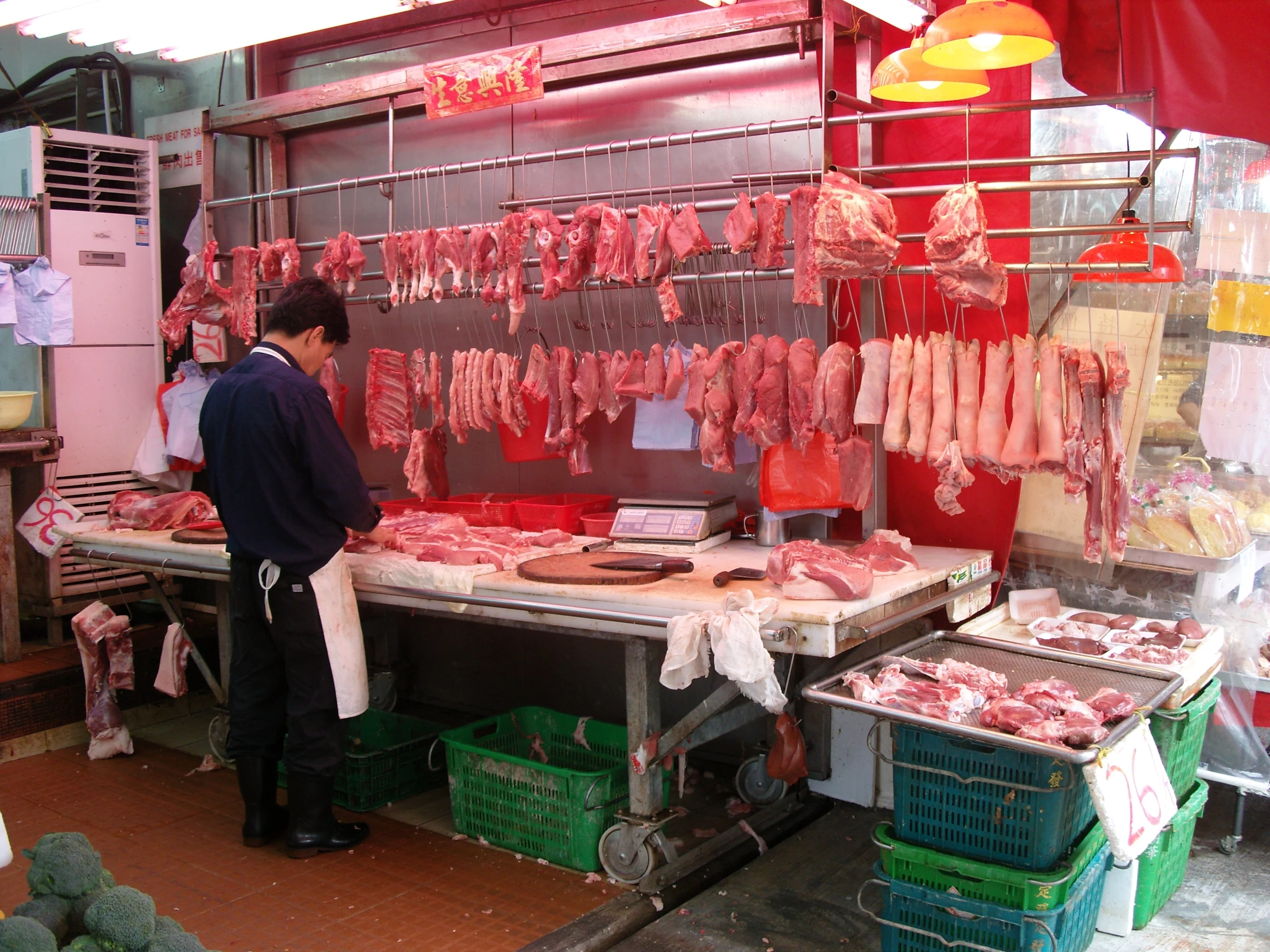 some people on a busy meat stand making a meaty dinner