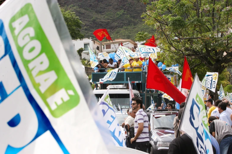 a group of people standing around flags and cars