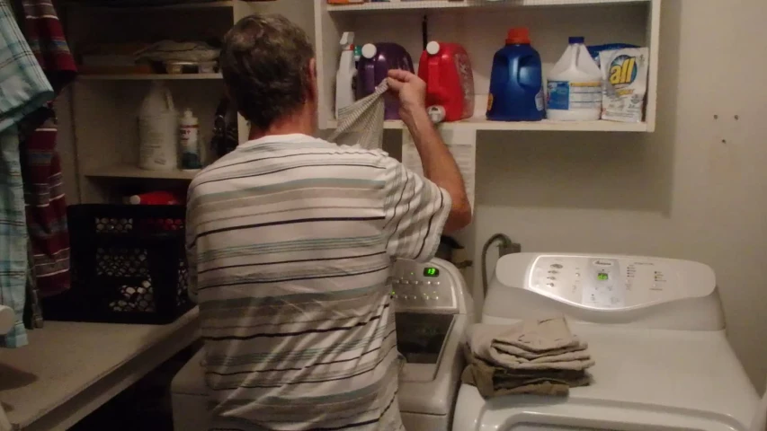 a man is trying to clean the dryer with a bottle