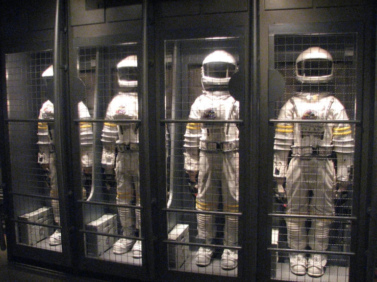 three people wearing space suits in a room