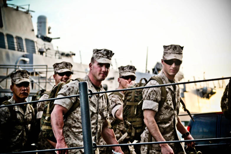 a group of men in uniforms walking on a deck