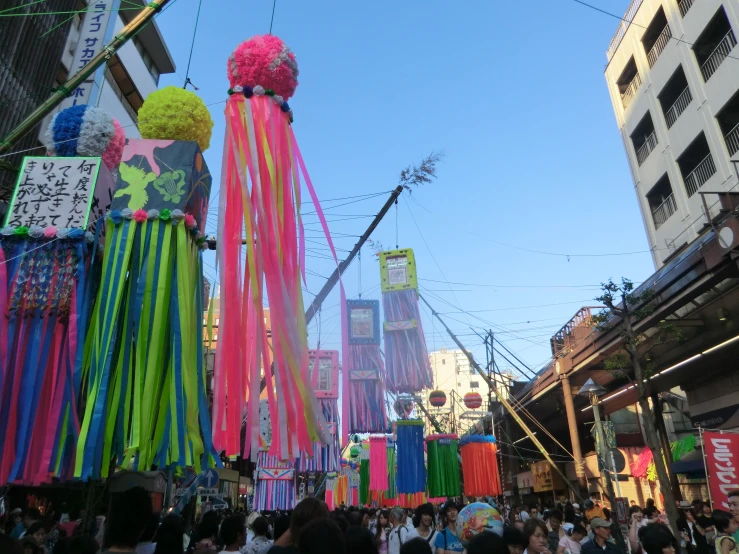 a crowd of people walking down a street next to tall buildings