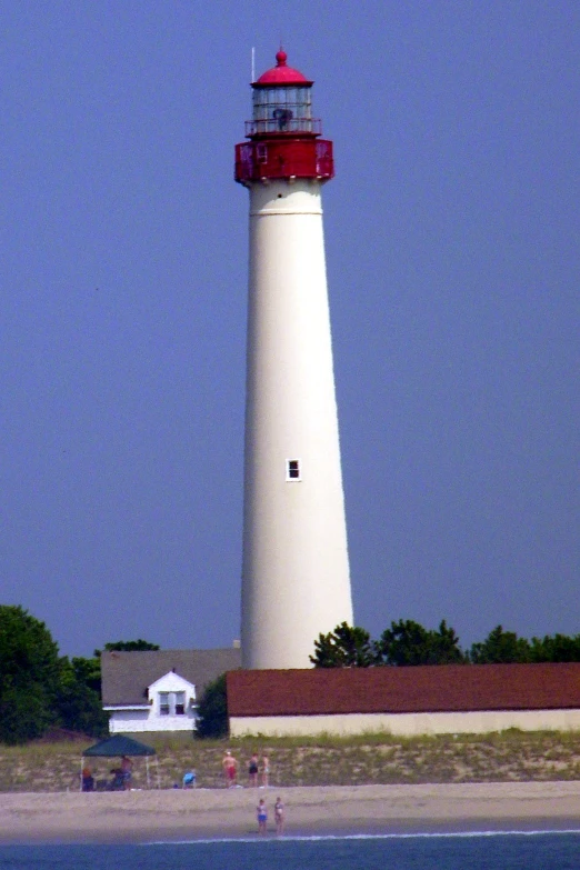 a red and white lighthouse next to the ocean