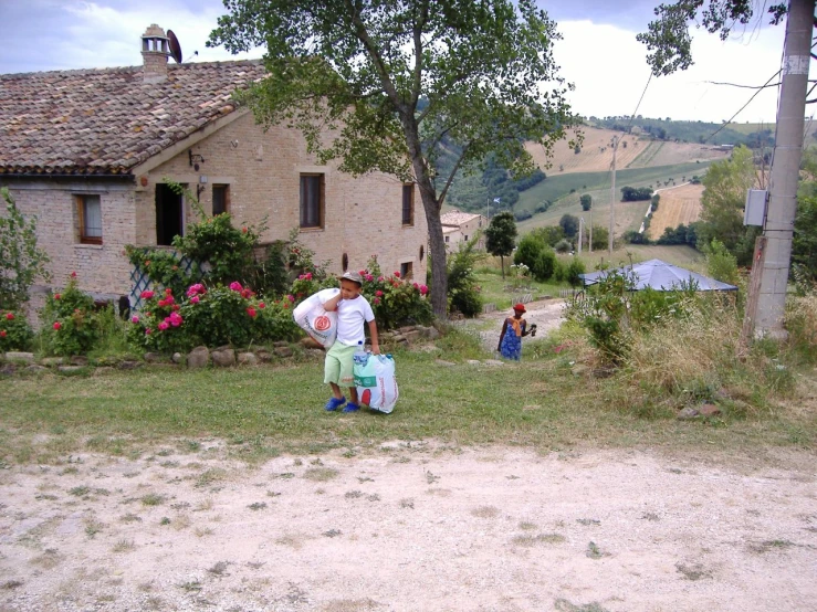 three people stand in front of a house near some dirt