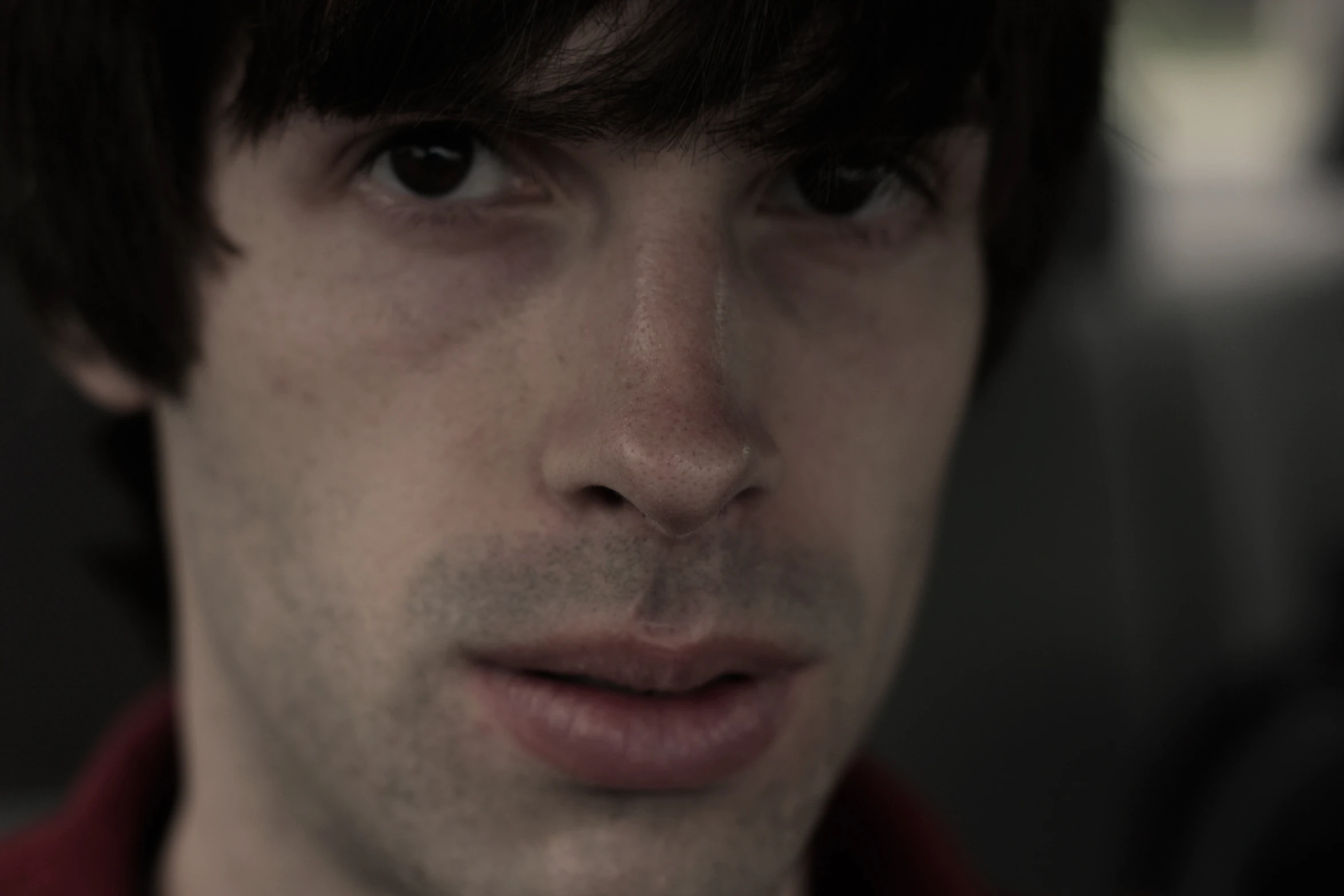 man with a red shirt staring at the camera