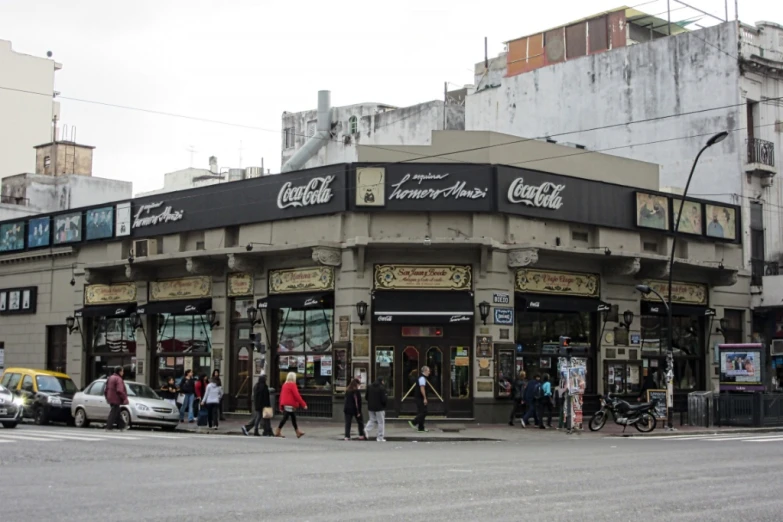 this is a picture of people walking on the sidewalk in front of a restaurant